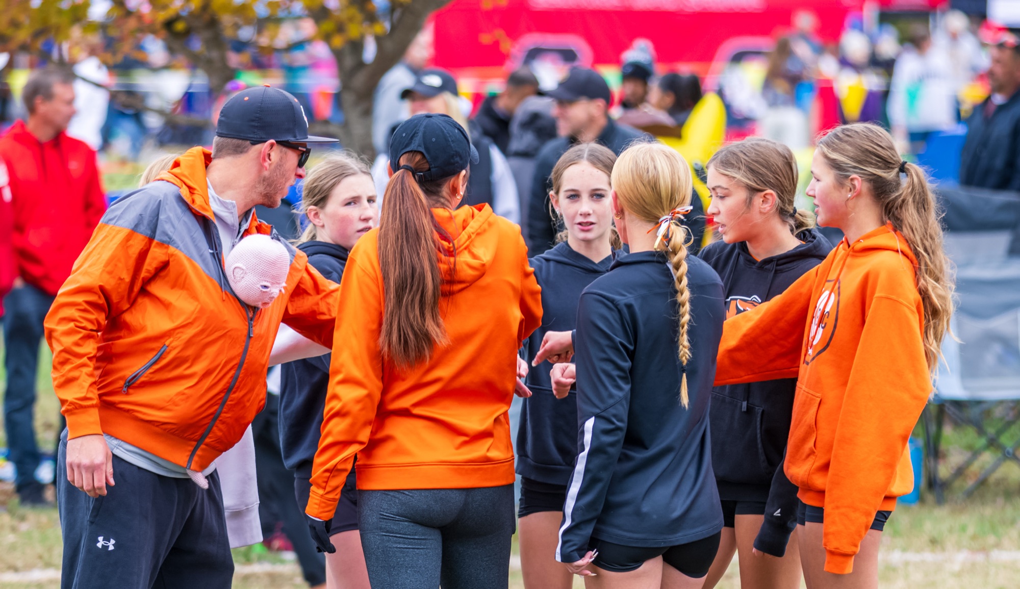 Kyle Crouch talks with the girls team in a huddle at the district meet