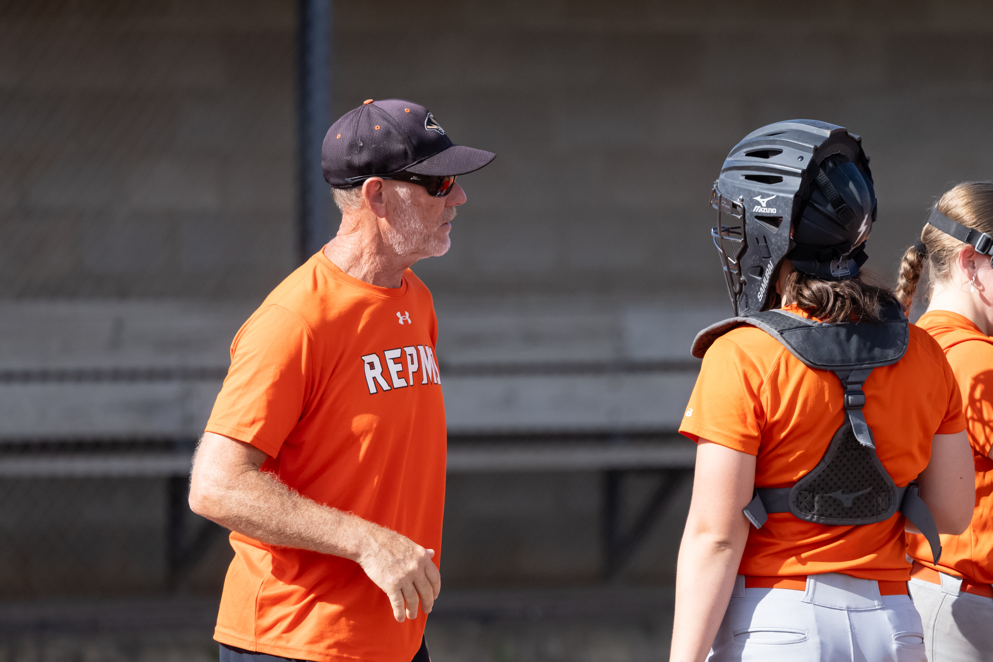 New Republic softball coach Denny McHenry talks with a catcher at practice